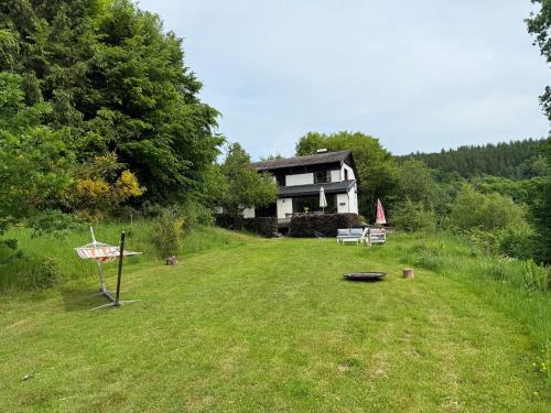 a house sitting on top of a lush green field at L'Orée de Borzée in La Roche-en-Ardenne