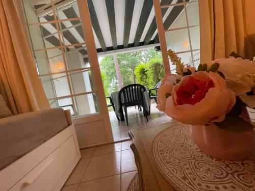 a vase with a flower on a table in a room at Joli appartement au golf in Biscarrosse