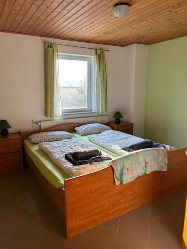 ein Schlafzimmer mit einem Holzbett mit Fenster in der Unterkunft Ferienwohnung Am Lilienstein in Bad Schandau