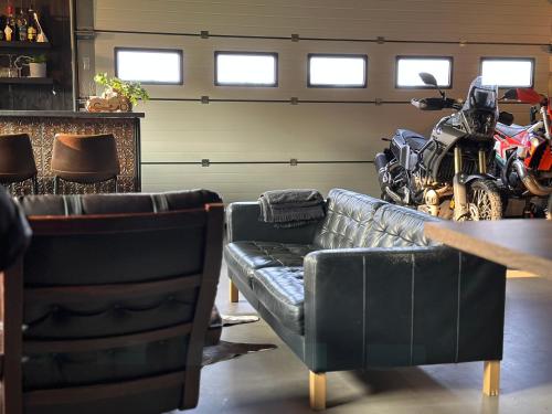 a garage with a couch and a motorcycle in it at Kõrvalhoone in Pirgu