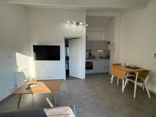un salon avec une table et une cuisine dans l'établissement T2 tout équipé proche des châteaux du médoc et de la côte Atlantique, à Arsac