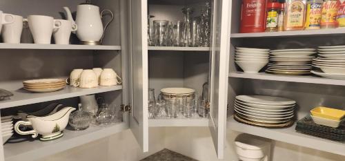 a cupboard filled with plates and bowls and dishes at Heavenly Home in New Haven in New Haven
