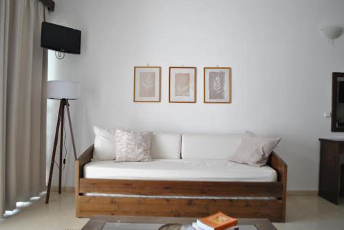a bed in a room with three pictures on the wall at Thalassa Studios in Loutrá Kounoupélli