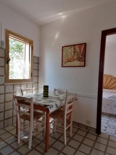a dining room with a table and chairs and a window at VillA LA PinetA in Favignana