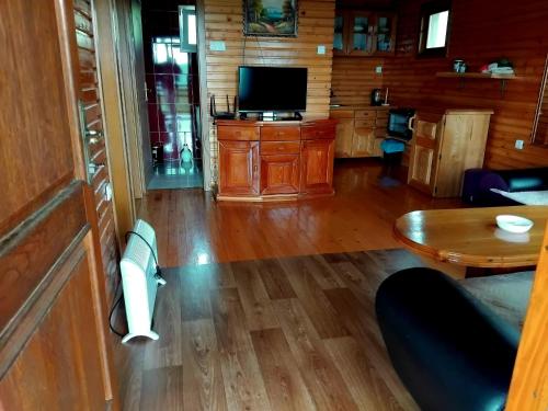 a living room with a television and a table at Ethno village & resort Ćorić in Mojkovac