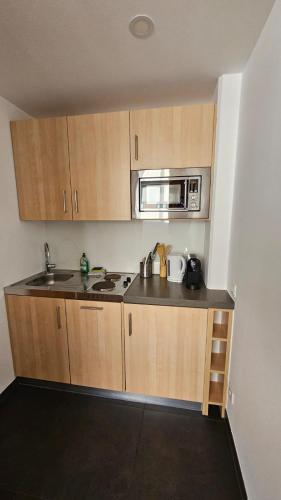 a small kitchen with a sink and a microwave at bookVienna "JiM" Apartments in Vienna