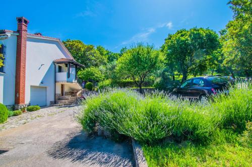 a house with a car parked in the driveway at Apartment Vincent with beautiful sea view terrace in Klenovica