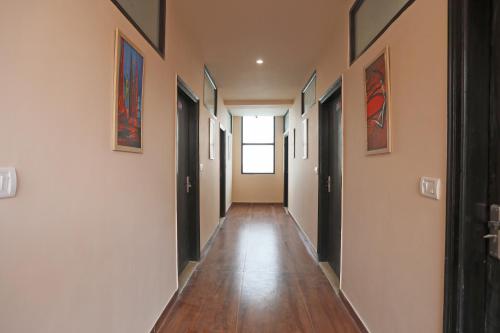 un pasillo de una casa con pinturas en las paredes en Hotel O DSG Residency, en Faridabad
