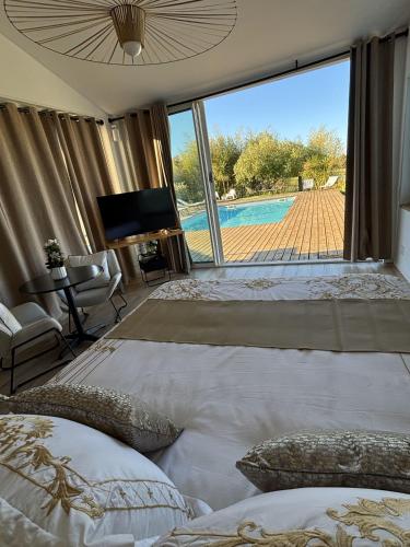 a bedroom with two beds and a view of a pool at Le Coucher de Soleil Spa in Bessens