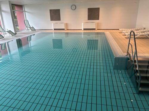 a swimming pool with green tiles on the floor at Ferienwohnungen im Taunusblick in Lahnstein