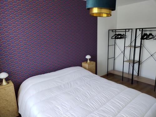 une chambre avec un lit blanc et un mur rouge dans l'établissement Charmante maison neuve au cœur de Matignon, à Matignon