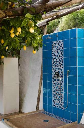 a blue tiled bathroom with a shower backdoor at Casa Pappalardo in Ravello