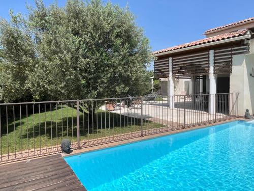une piscine avec une clôture à côté d'une maison dans l'établissement Lou pastre, à Saint-Rémy-de-Provence