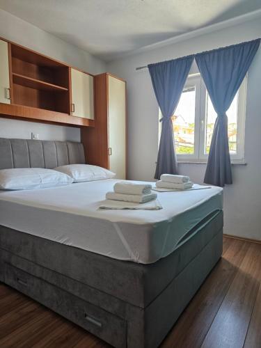 a bedroom with a large bed with blue curtains at Apartment MILA in Senj
