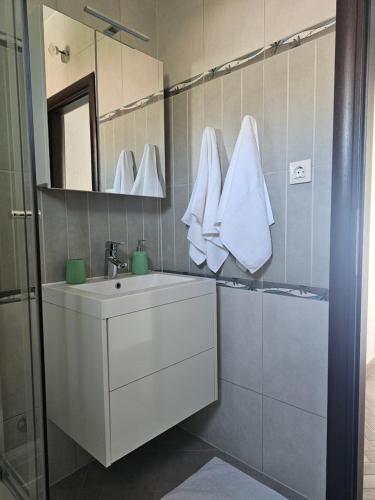 a bathroom with a white sink and a mirror at Apartment MILA in Senj
