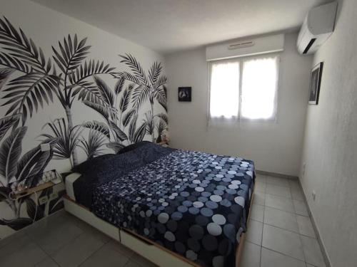 - une chambre avec un lit et une plante sur le mur dans l'établissement Appartement cosy dans résidence avec piscine, à Saint-Raphaël