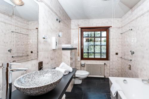 a bathroom with a tub and a sink and a toilet at Gästehaus Obsthof Gottenheim in Gottenheim