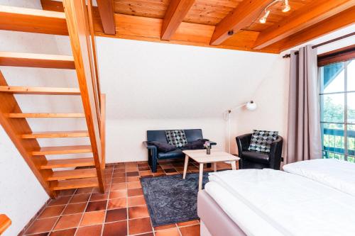 a room with a bed and two chairs and a table at Gästehaus Obsthof Gottenheim in Gottenheim