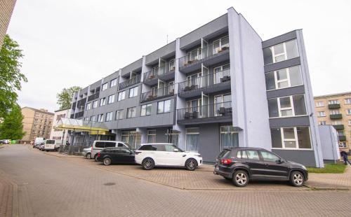 a group of cars parked in front of a building at Hotel Vento in Ventspils
