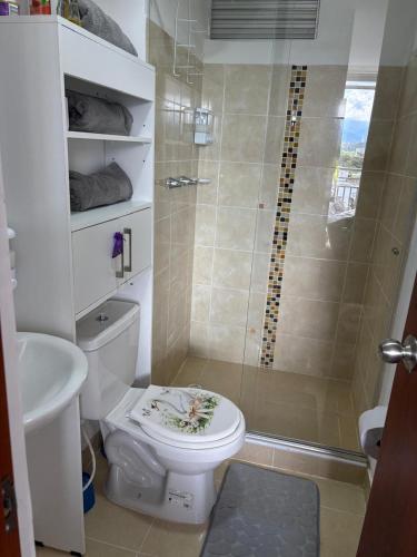 a bathroom with a shower and a toilet with a toilet seat at Mi hogar en Ibagué in Ibagué