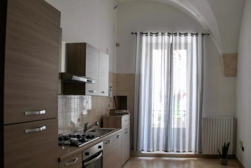una cucina con un lavello e una grande finestra di Dimora Nuccio a Martina Franca