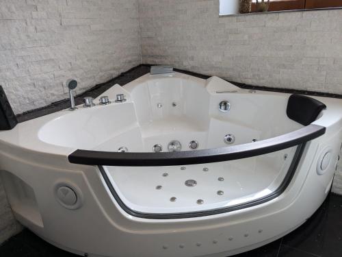 a large white bath tub in a room at Altes Häusle am Waschbach Anno 1625 Ferienwohnungen und Doppelzimmer in Edenkoben