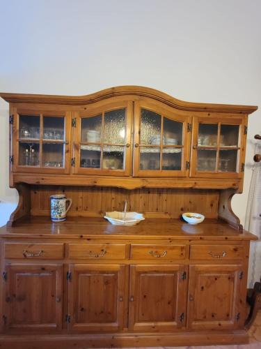a large wooden cabinet with glass doors at Etna view Villa Letizia a Taormina in Taormina
