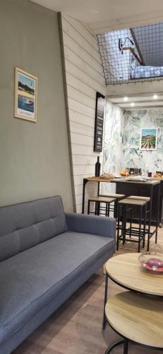 une pièce avec un canapé et des tables et une cuisine dans l'établissement Charme et Nature, appartement cosy avec étang privé, au carrefour de 3 départements, à Saint-Aigulin