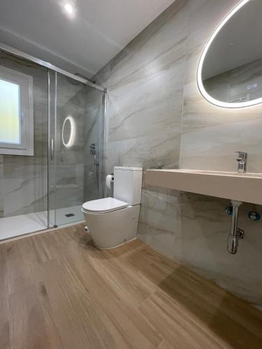 a bathroom with a toilet and a sink and a shower at Sunset Palm in El Puerto de Santa María