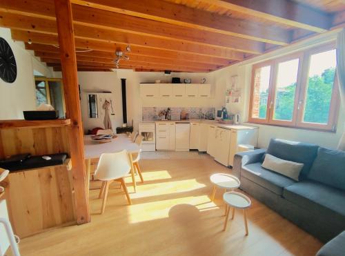 un salon avec un canapé bleu et une cuisine dans l'établissement Petite maison en bord d'Allier, à Villeneuve-dʼAllier