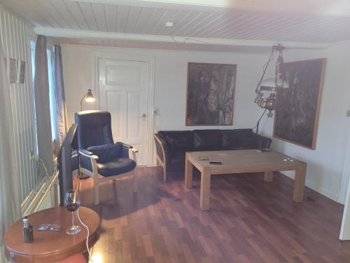 a living room with a black couch and a table at Lejbølle Gamle Bageri in Tranekær