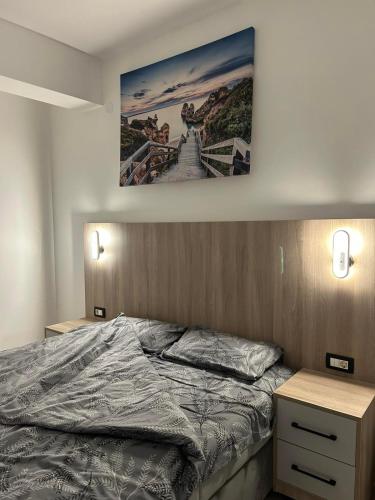 a bedroom with a bed and a painting on the wall at I&I Apartment in Igalo