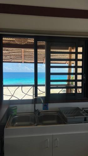 a view of the beach from a kitchen window at Fareana Lodge Bungalow ho'e in Fakarava
