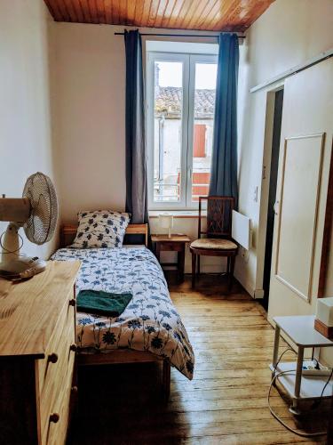 une chambre avec un lit, un bureau et une fenêtre dans l'établissement Gite d'étape Canal de Garonne, à Buzet-sur-Baïse