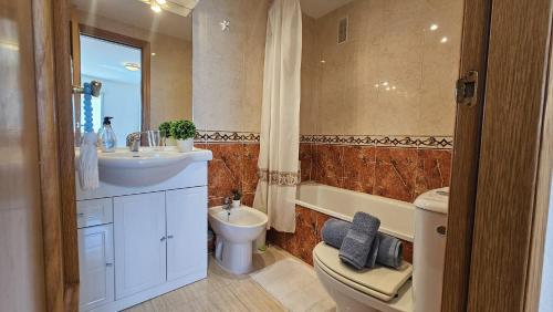 ein Badezimmer mit Waschbecken, Toilette und Badewanne in der Unterkunft Oasis Marino in El Borseral