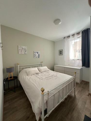 une chambre avec un lit blanc et une fenêtre dans l'établissement La Loge du Théâtre, à Orange