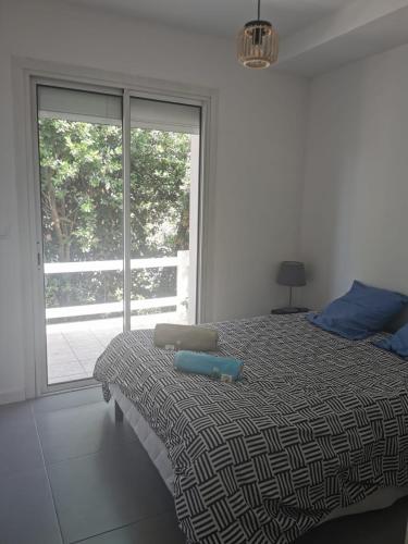 une chambre avec un lit et une grande fenêtre dans l'établissement Maison Cosy au Cœur de St-Jean, à Saint-Jean-de-Védas