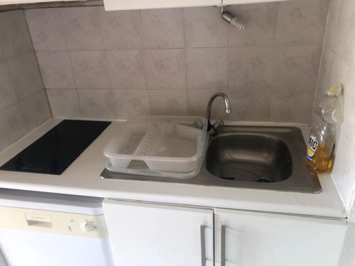 - un comptoir de cuisine avec évier et une bouteille d'alcool dans l'établissement Palavas,T2 mezz terrasse parking, à Palavas-les-Flots