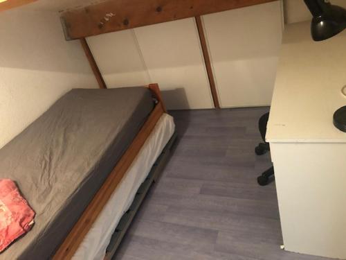 une petite chambre avec un lit et un bureau dans l'établissement Palavas,T2 mezz terrasse parking, à Palavas-les-Flots