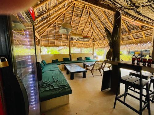 a living room with a tent with a couch and chairs at Downwinder Lagoon Lodge in Kalpitiya