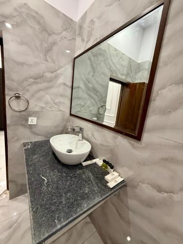 a bathroom with a sink and a mirror at Marina Suites Lahore in Lahore