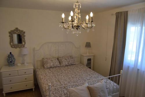 een slaapkamer met een bed en een kroonluchter bij Family House Stara Novalja in Stara Novalja