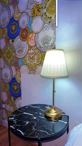 une lampe sur une table à côté d'un mur dans l'établissement Rigate spa, à Lens