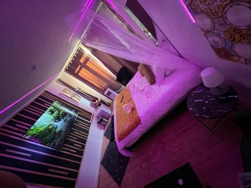 - une chambre avec un lit violet dans l'établissement Rigate spa, à Lens