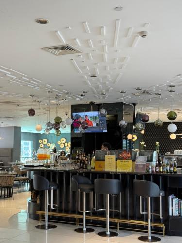 a bar in a restaurant with black bar stools at Novotel Suites Manila by River Luxury in Manila