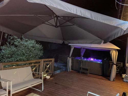 a large umbrella on a deck with a stage at Eden nad Lubie Linowno in Linowo