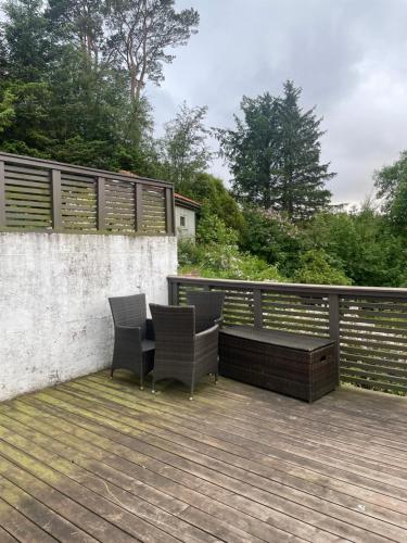 two chairs and a table on a deck at Flott sted med utsikt over hele byen in Stavanger
