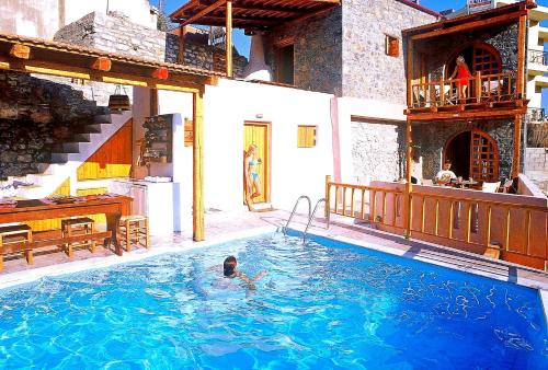 a man in a swimming pool in a house at Elounda Traditional Homes of Crete in Elounda