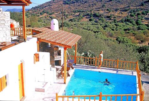a woman standing in a swimming pool on a house at Elounda Traditional Homes of Crete in Elounda