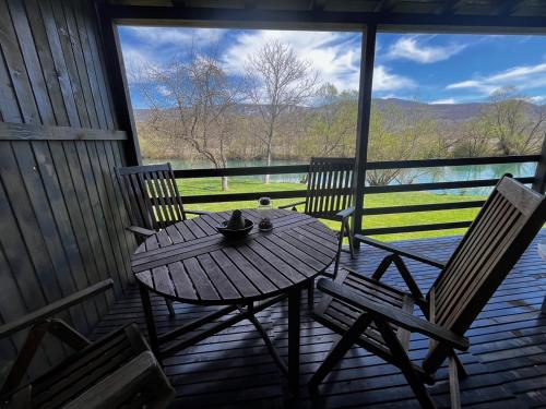 a table and chairs on the porch of a cabin at Una Meryland in Kulen Vakuf
